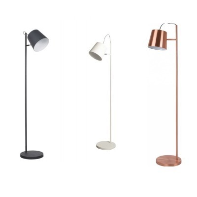 Três candeeiros de pé preto, branco e cobre com abajur inclinado