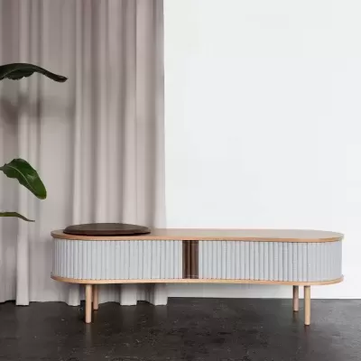 Móvel de apoio em madeira clara com portas listradas cinzentas e acabamento natural