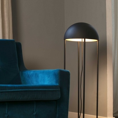 Candeeiro de pé preto junto a poltrona azul num ambiente interior