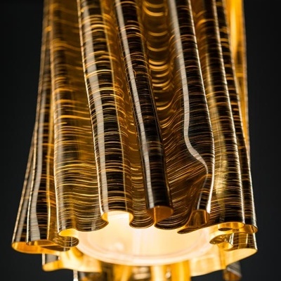 Candeeiro pendente dourado com textura estriada e luz ligada