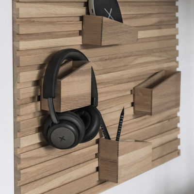 Painel de organização em madeira com suportes e auscultadores pretos