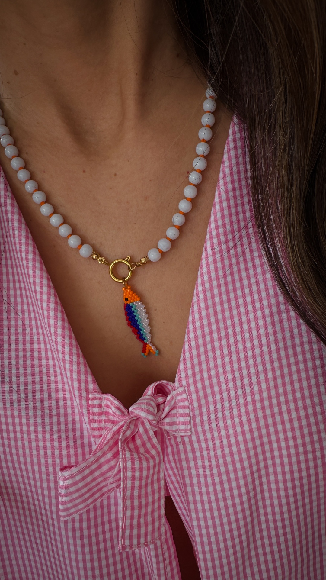 Colares SARDINHAS Colar de contas branca com pendente colorido em forma de peixe e blusa rosa xadrez