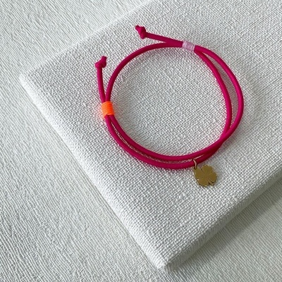 Pulseira vermelha com medalha de folha em tecido branco