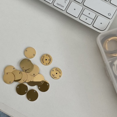 Discos redondos dourados metálicos com inscrições, teclado branco e caixa plástica transparente