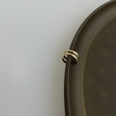 Anel metal dourado em prato cerâmico castanho