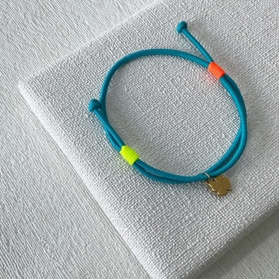 Pulseira azul turquesa com pendente de trevo dourado