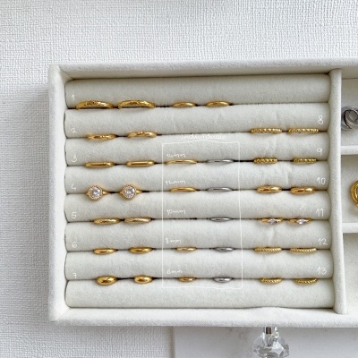 Caixa branca com anéis dourados e prateados em tiras acolchoadas