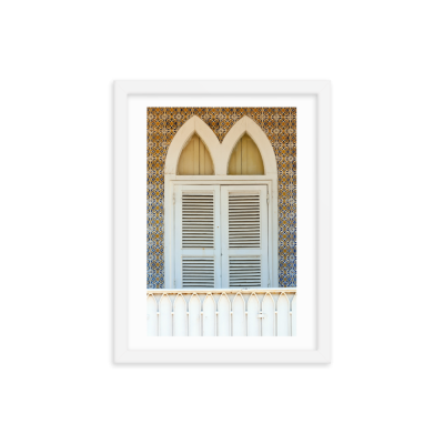 Janela dupla branca com venezianas e azulejos coloridos ao fundo, em moldura branca