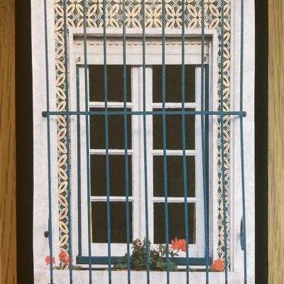 Capa de caderno com imagem de janela branca com grade azul e azulejos decorativos