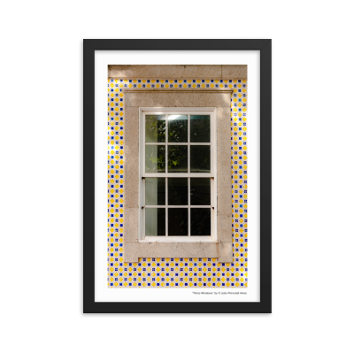 Janela branca com azulejos amarelos, azuis e brancos à volta, fotografada emoldurada
