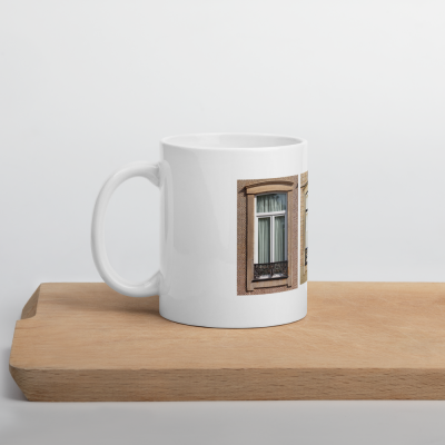 Caneca branca com imagem de janela com moldura castanha e cortina branca