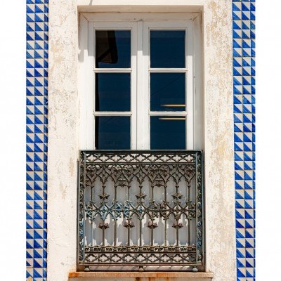 Janela dupla branca com grades de ferro e azulejos azuis geométricos na parede