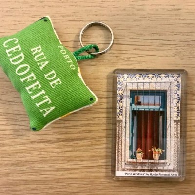 Chaveiros com texto e imagem de janela sobre superfície de madeira clara