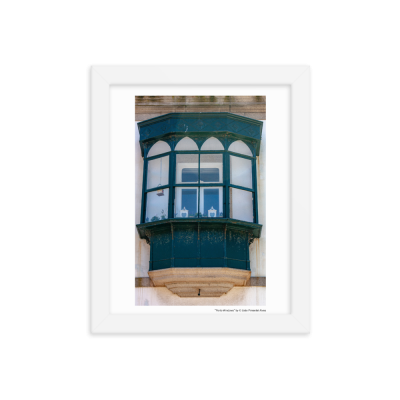 Janela saliente verde escura com moldura branca numa parede de pedra clara