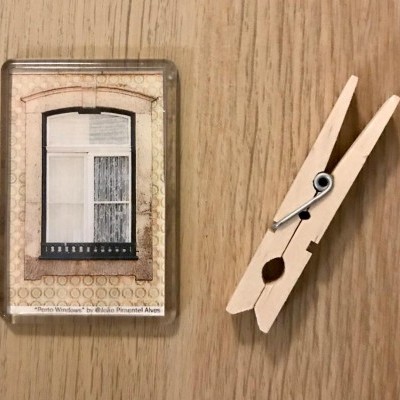 Cartão plástico com imagem de janela antiga ao lado de prendedor de madeira