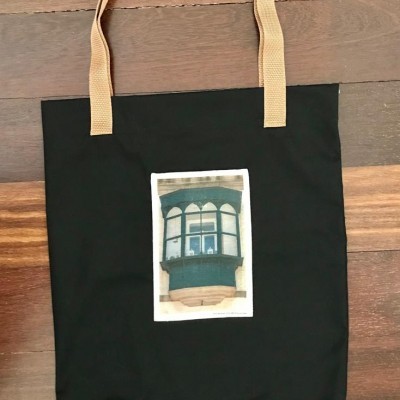 Saco preto de tecido com alças castanhas e imagem de janela antiga verde