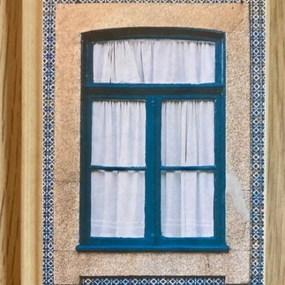 Caderno com capa ilustrada de janela azul e azulejos em tom azul e branco.