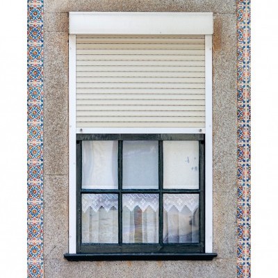 Janela com persiana branca, cortina rendada e azulejos decorativos