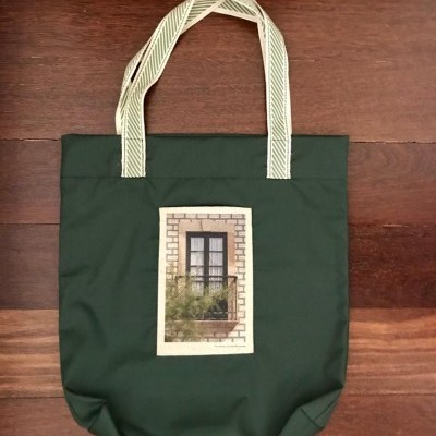 Saco tote verde com imagem de janela e alças com padrão ziguezague