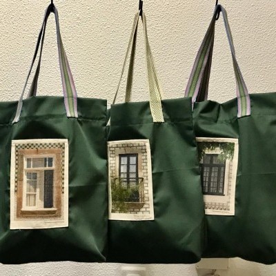 Três sacos verdes com imagens de janelas impressas