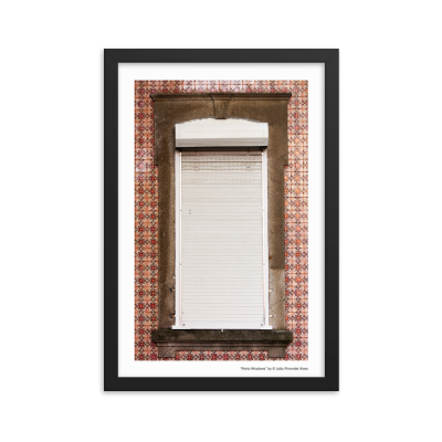 Janela branca com persiana fechada e moldura de pedra, rodeada por azulejos vermelhos e castanhos