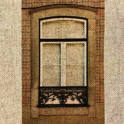 Janela antiga com moldura de pedra e grade preta decorativa