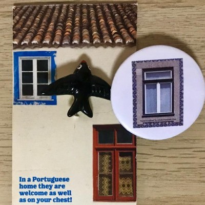 Ímanes com imagens de janelas e pássaro sobre superfície de madeira clara