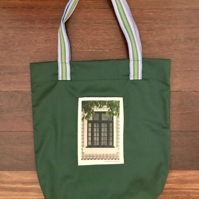 Bolsa verde escuro com alças multicoloridas e estampa de janela