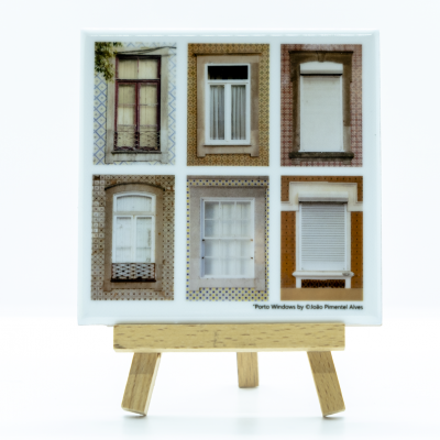 Quadro com seis fotografias de janelas tradicionais de edifícios, exposto numa base de madeira.