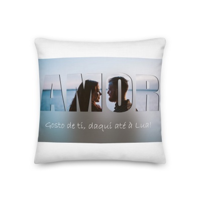 Almofada branca com texto AMOR e silhueta de duas faces humanas, frase em português abaixo.