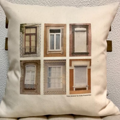 Almofada bege com seis imagens de janelas em molduras coloridas