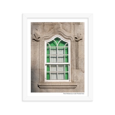 Janela branca com vidros verdes e brancos numa parede de pedra cinzenta, emoldurada num quadro branco