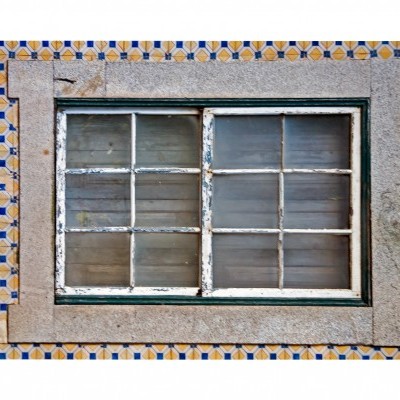 Janela de madeira emoldurada por azulejos coloridos com padrão geométrico