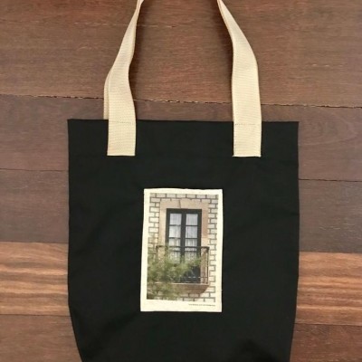 Saco de tecido preto com pegas bege e estampa de janela com tijolos