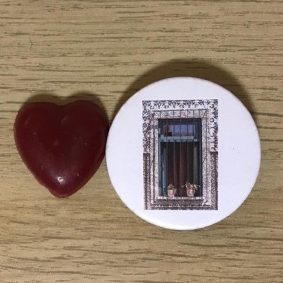 Coração vermelho e botão redondo branco com janela antiga em fotografia