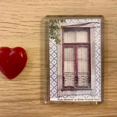 Caixa transparente com imagem de janela e objeto coração vermelho ao lado