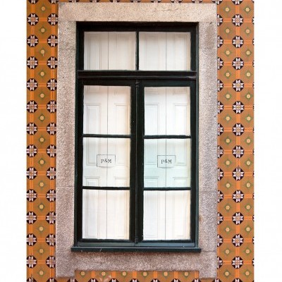 Janela preta com painel branco contra parede de azulejos laranja geométricos