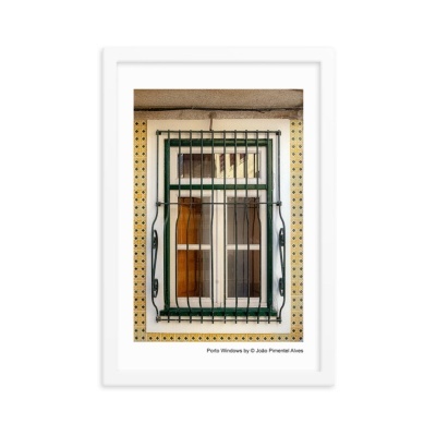 Janela com moldura branca e verde e grades metálicas verdes numa parede amarela com padrão preto