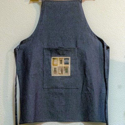 Avental escuro com bolso e imagem de quatro janelas coloridas