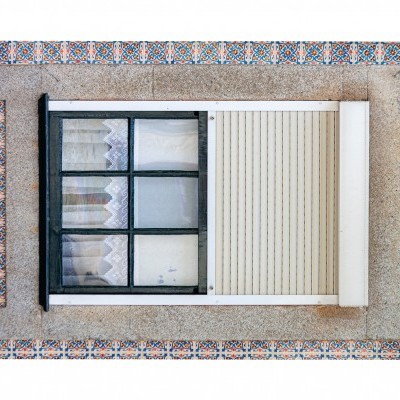 Janela com caixilho preto e azulejos coloridos na parede