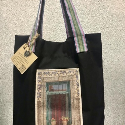 Mala preta de tecido com alças coloridas e estampa de janela