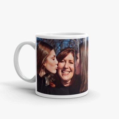 Caneca branca com fotografia de três mulheres, duas beijando a terceira ao centro