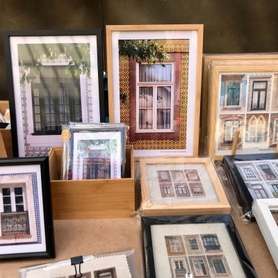 Fotografias emolduradas de janelas coloridas e variadas dispostas numa mesa.