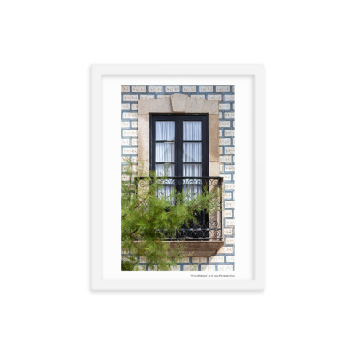 Janela de guilhotina com moldura de pedra, grade de ferro preta e azulejos azuis e brancos na parede exterior