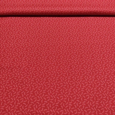 Rolo de tecido vermelho com padrão branco repetitivo