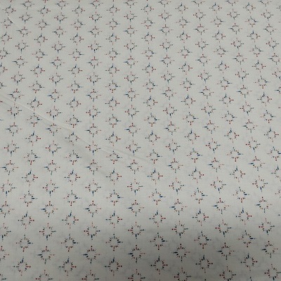 Tecido branco com padrão de desenhos florais pequenos azuis e vermelhos em losangos.