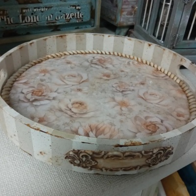 Tabuleiro redondo de madeira com padrão floral e riscas brancas e bege