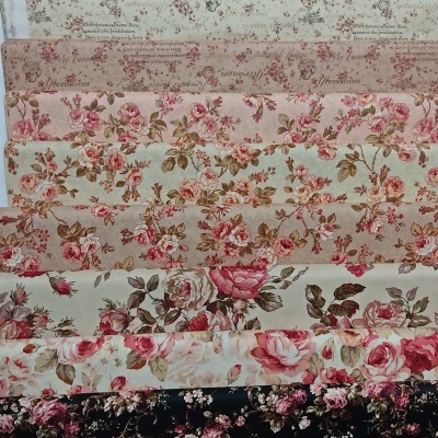 Rolos de tecido com padrões florais e texto em várias cores alinhados