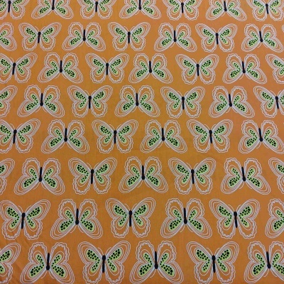 Tecido com padrão de borboletas verdes, pretas e brancas sobre fundo cor de laranja