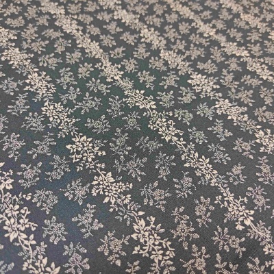 Tecido verde-escuro com padrão floral branco